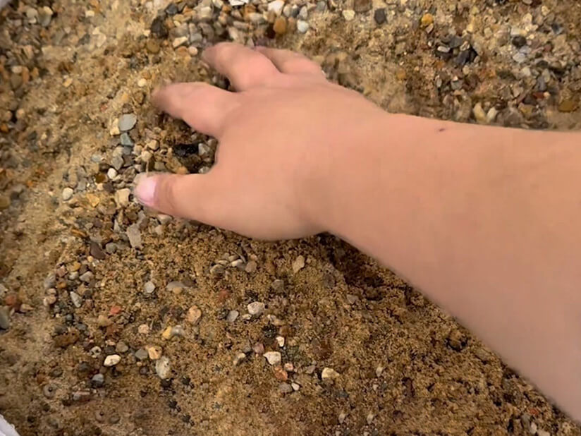 Hånd der håndterer støbemix i bigbag