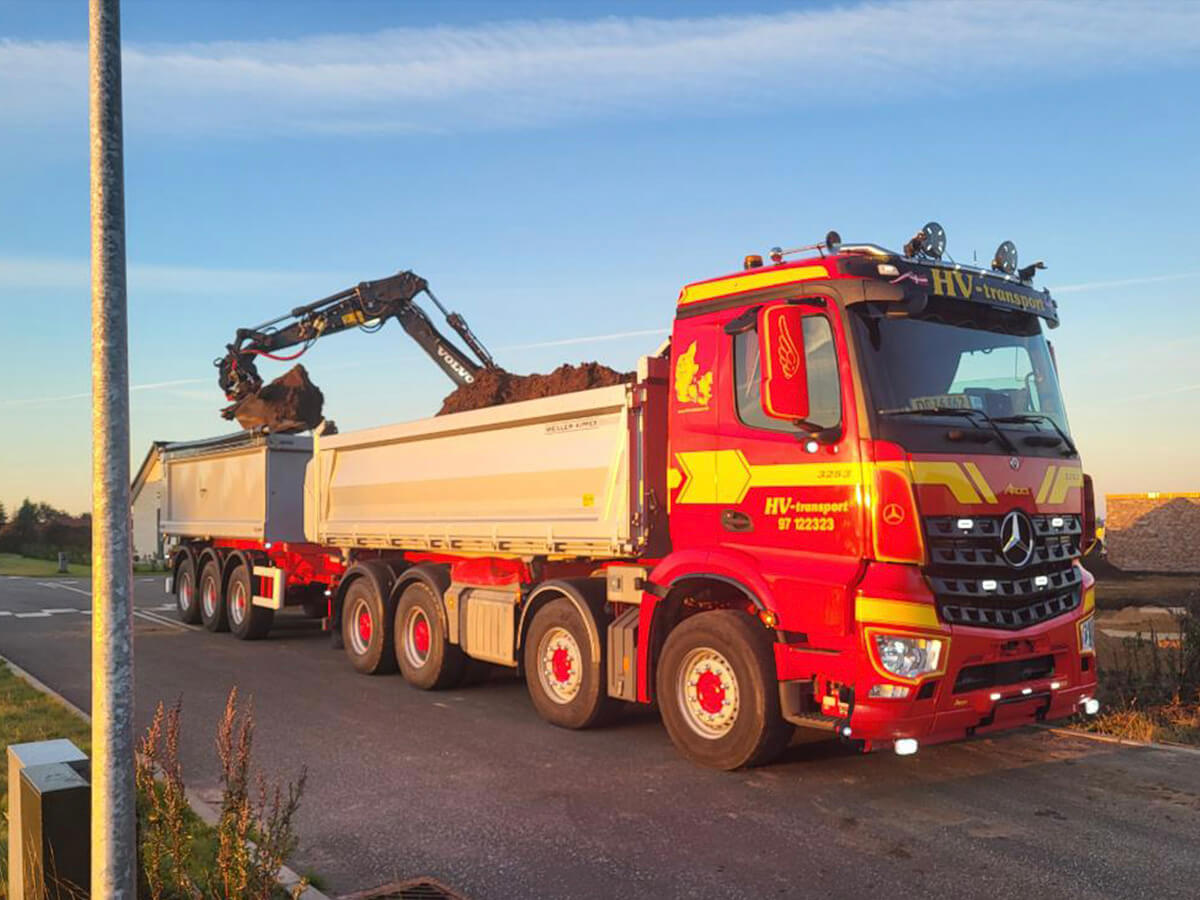 Moderne vognpark med lastbiler på række, klar til at levere og hente materialer