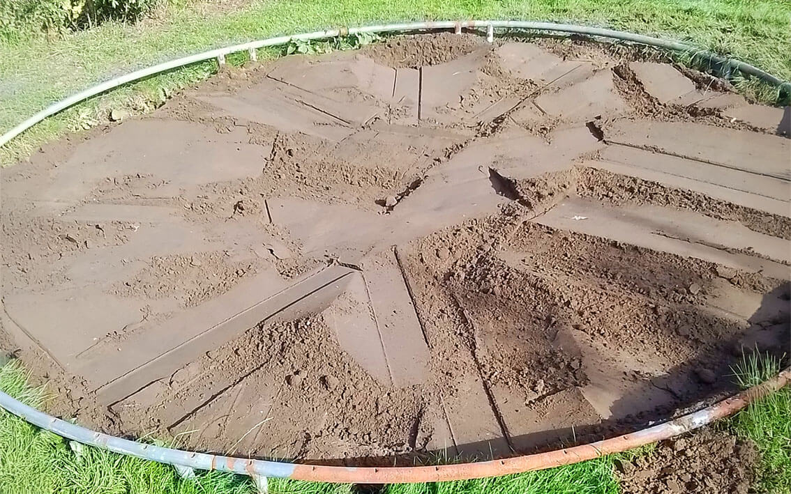Trampolinhul fyldt op med jord og klar til græs