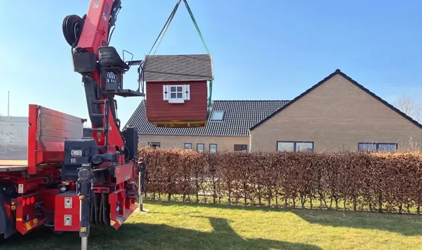 Legehus bliver løftet af en kran