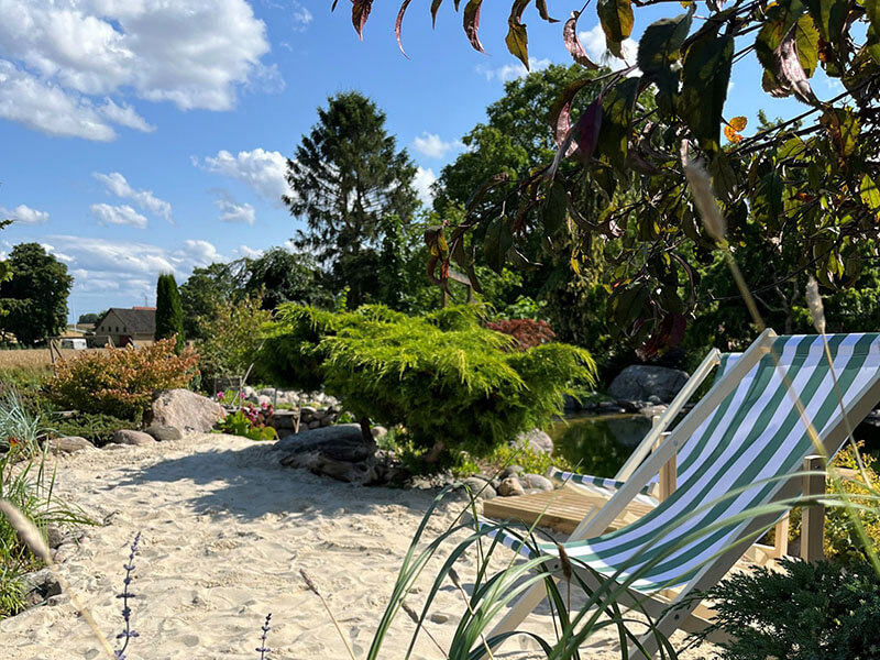 En strandstol placeret i strandsand ud til en badesø